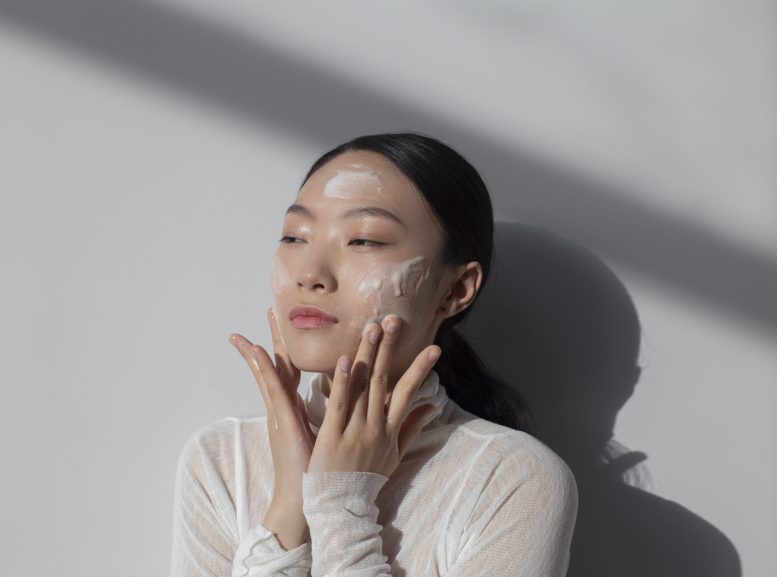 hermosa-mujer-asiatica-posando-con-crema-facial